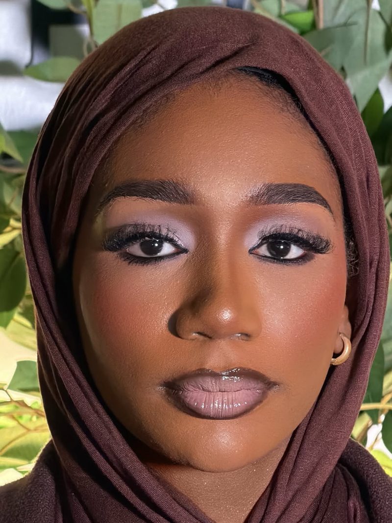 Close portrait: lilac eyeshadow, full lashes, sculpted brows, glossy mauve lip