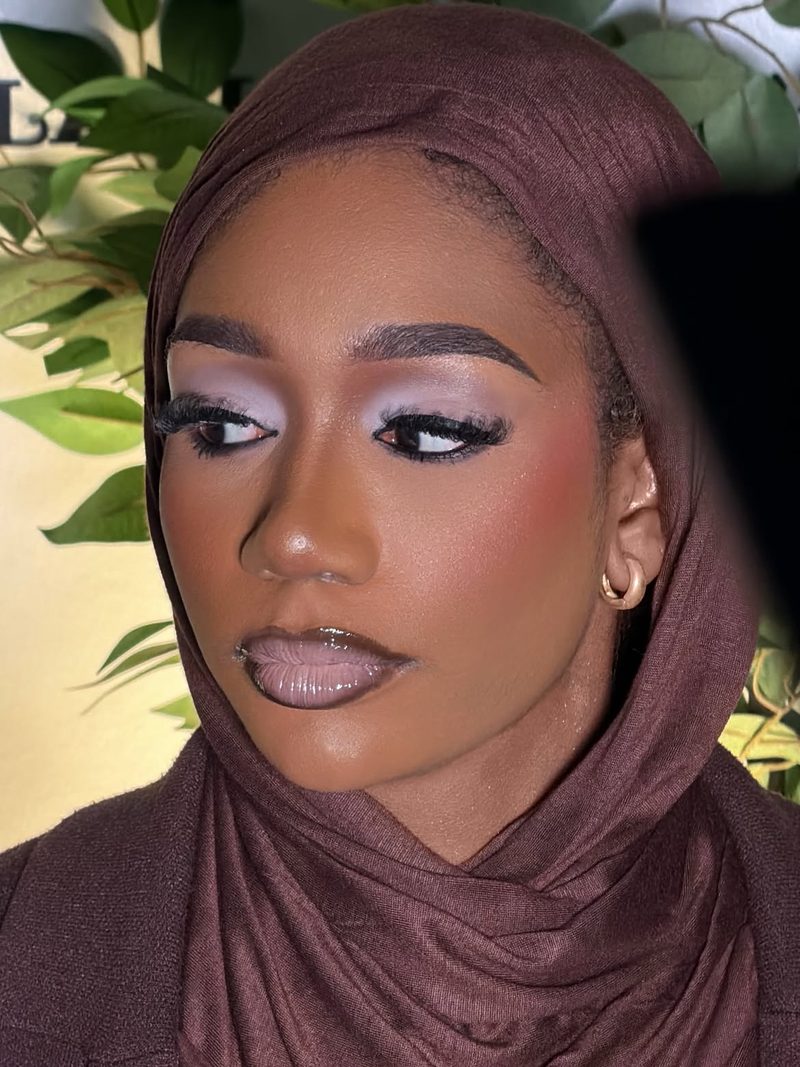 Lilac eyeshadow and mauve gloss, eyes glancing to the side, brown headscarf